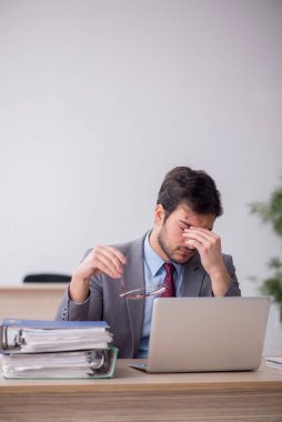 Young employee unhappy with excessive work at workplace
