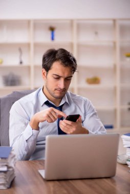 Genç işadamı ve işyerinde çok fazla iş var.