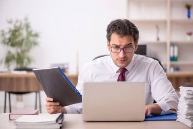 Genç işadamı ve işyerinde çok fazla iş var.