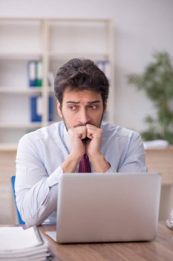 Young employee and too much work at workplace