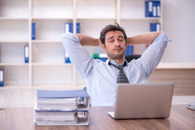 Ofisteki aşırı işten memnun olmayan genç bir çalışan.