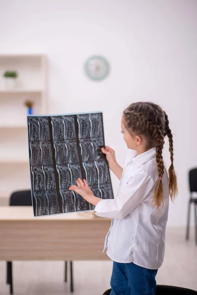 Little girl playing doctor radiologist at the hospital