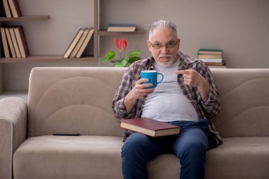 Old man sitting at home during pandemic
