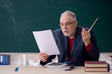 Old teacher sitting in the classroom