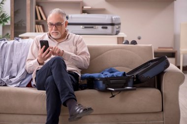 Aged man preparing for trip at home