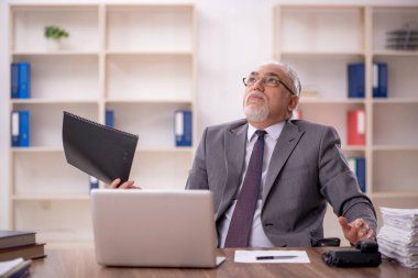 Ofiste çalışan eski bir işadamı.