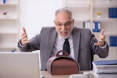 İş yerinde pasta yiyen eski bir işadamı.