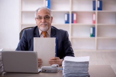 Ofisteki aşırı işten memnun olmayan eski bir işadamı.