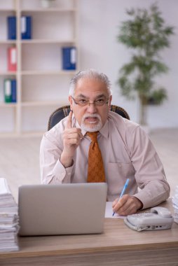 Ofisteki aşırı işten memnun olmayan eski bir işadamı.