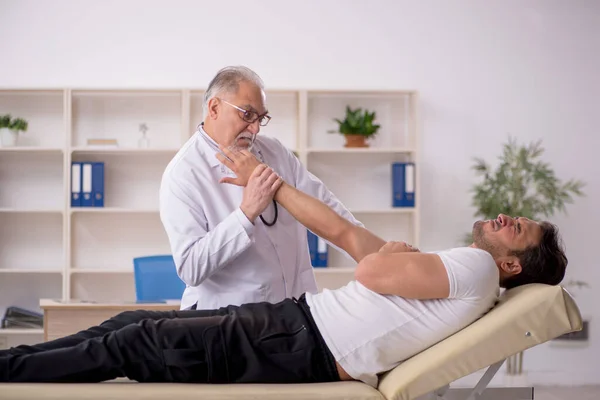 Young Doctor Visiting Old Doctor Chiropractor — Stock Photo, Image