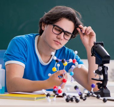 Sınıftaki genç erkek öğrenci.