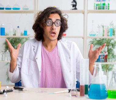 Laboratuvarda çalışan komik erkek kimyager.