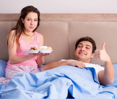 Mutlu aile yatakta kahvaltı yapıyor.