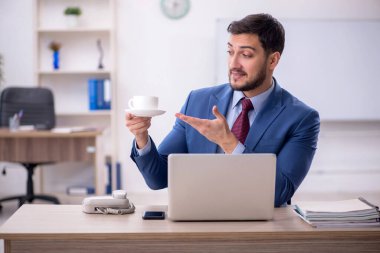 İş yerinde kahve içen genç bir çalışan.