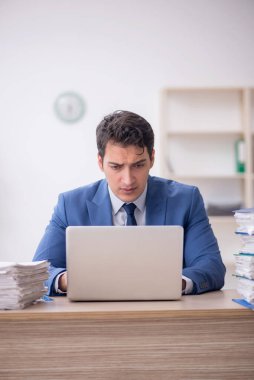 Genç işadamı ve işyerinde çok fazla iş var.