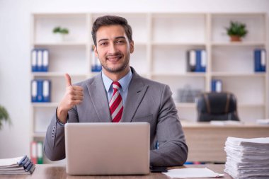 Genç işadamı işyerinde oturuyor.