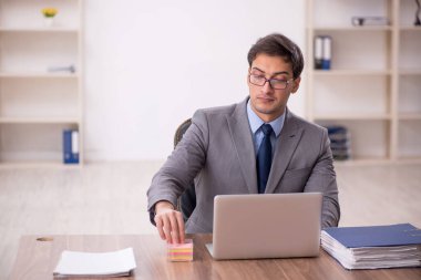 Genç işadamı işyerinde oturuyor.