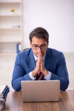 Genç işadamı işyerinde oturuyor.