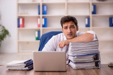 Genç işadamı ve ofiste çok fazla iş var.