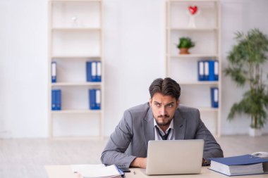 Genç işadamı işyerinde oturuyor.