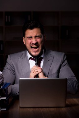 Young employee working late at workplace