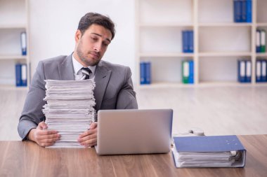 Genç bir çalışan ve ofiste çok fazla iş var.