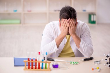 Young chemist sitting at the lab
