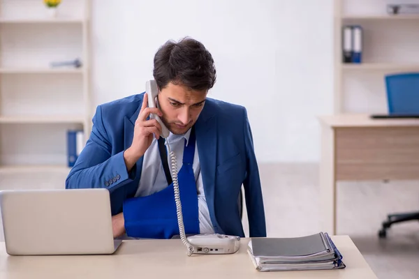 Young businessman employee after car accident in the office