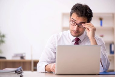 Genç işadamı ve işyerinde çok fazla iş var.