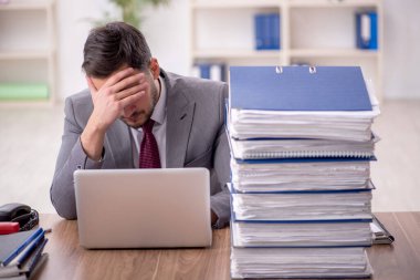 Genç bir çalışan ve ofiste çok fazla iş var.