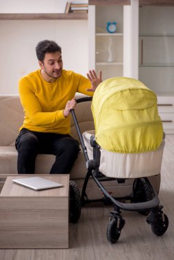 Young contractor looking after baby at home