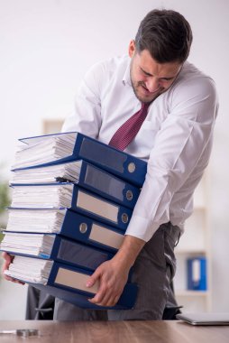 Genç bir çalışan ve ofiste çok fazla iş var.