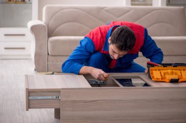 Evde çalışan genç bir marangoz.