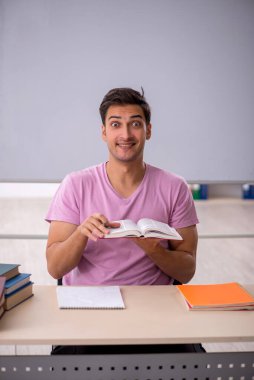 Sınıfta sınava hazırlanan genç bir öğrenci.