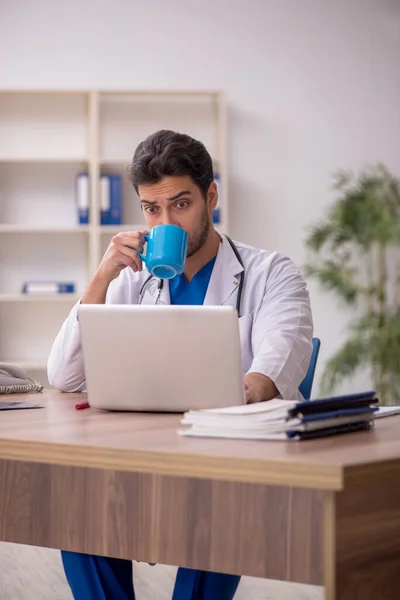 Young doctor drinking tea during break