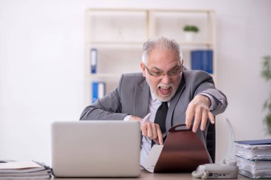 İş yerinde pasta yiyen eski bir işadamı.