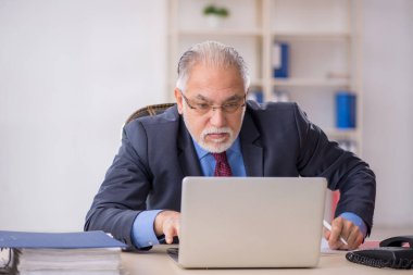 İş yerinde çalışan yaşlı bir işadamı