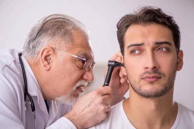 Young doctor visiting old doctor otolaryngologist