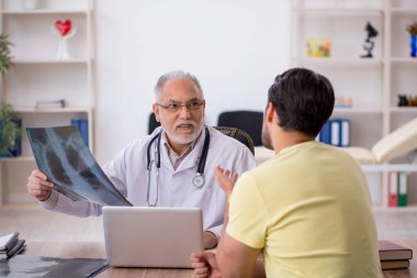 Genç doktor yaşlı doktoru ziyaret ediyor.