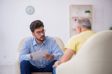 Yaşlı adam genç psikoterapisti ziyaret ediyor.