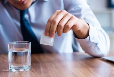 Ofiste acı çeken hasta erkek çalışan.