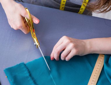 Kadın terzi dikiş dikmek için dikiş dikiyor.