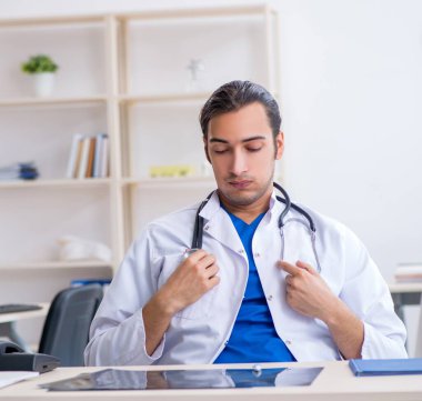 Klinikte çalışan genç erkek doktor.