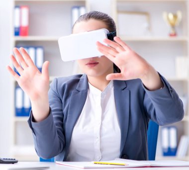 Ofiste sanal gerçeklik gözlüklü iş kadını.