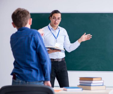 Sınıftaki genç erkek öğretmen ve çocuk.