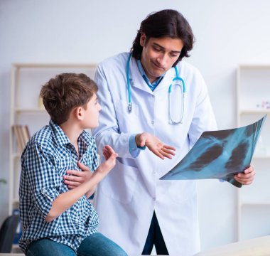 Erkek radyoloji uzmanı erkek çocukların resimlerine bakıyor.