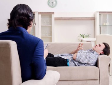 Genç erkek hasta psikologla kişisel sorunları tartışıyor.