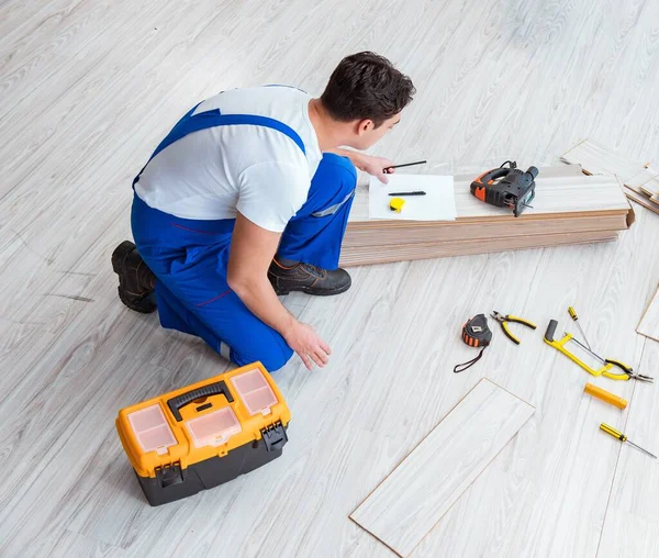 修理工は家で積層床を敷設 — ストック写真