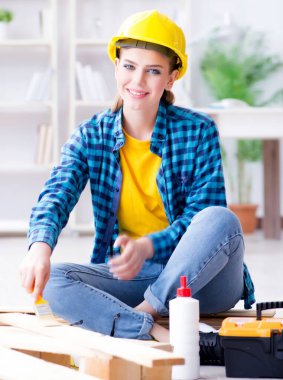 Tamirci kadın marangoz, ahşap döşemeleri onarım için kesiyor.