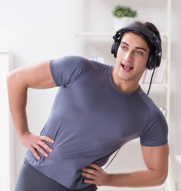 Evde spor yapan ve müzik dinleyen adam.